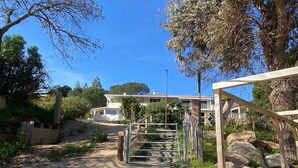 A dirt path leading to a gated entrance with a wooden structure on the right. - Appartement T3 - 50M de la Plage -rupione (Pietrosella)