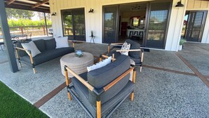 Ein Sitzbereich im Freien mit einer Couch, Stühlen und einem runden Tisch.