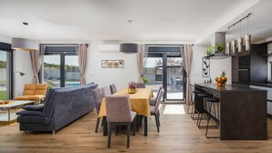 Ein zeitgemäßer Wohnbereich mit Essplatz, Sofa und Küche.