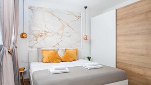 Ein modernes Schlafzimmer mit einem großen Bett, einer Wandkunst aus Marmor und einer Wandverkleidung aus Holz.