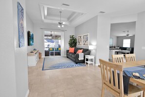 Un salon moderne comprenant un canapé, une table basse et un coin repas avec des chaises et une table.