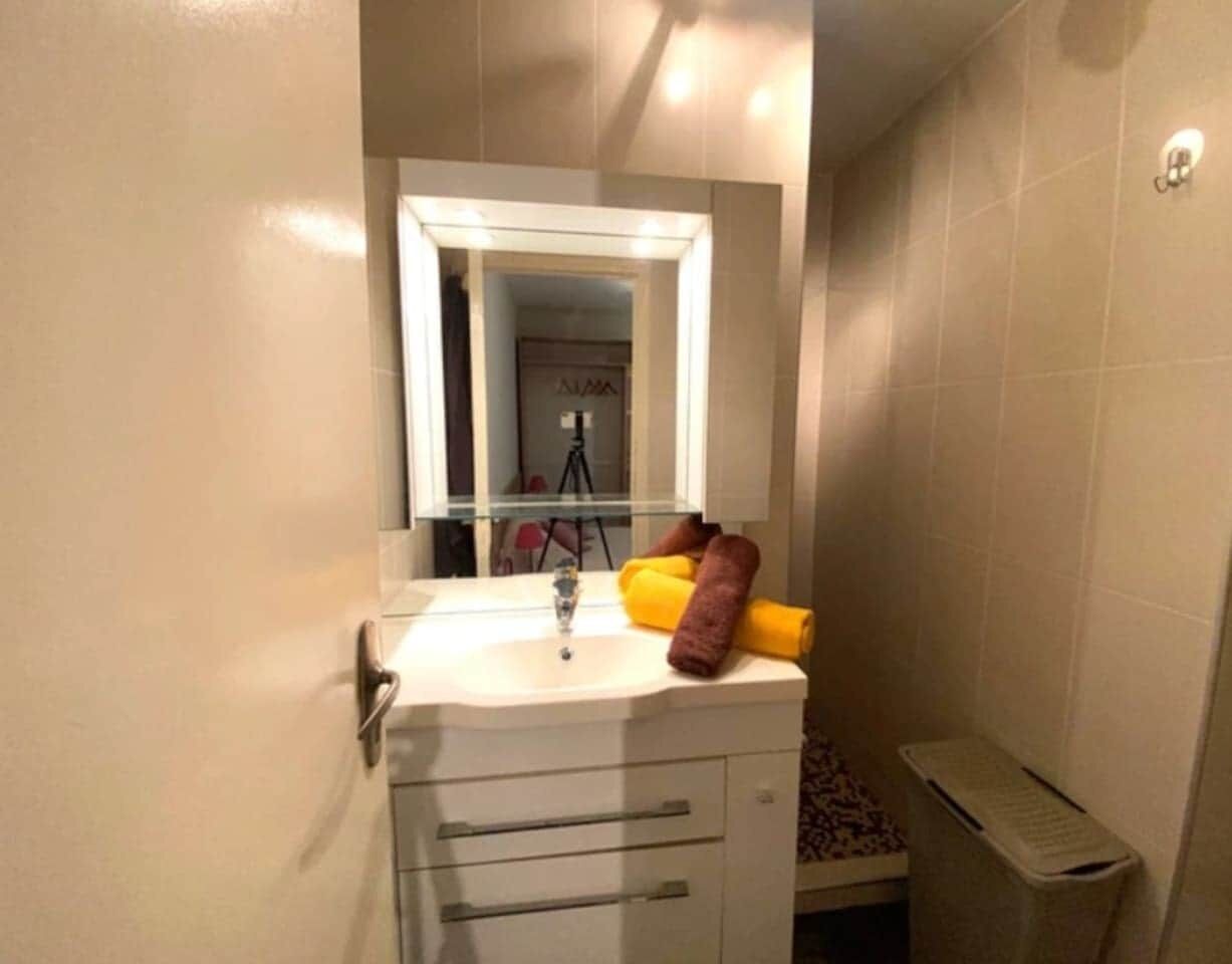 A bathroom with a sink, mirror, and towel rack.