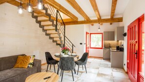 A modern interior with a staircase, dining area, kitchen, and red doors. - Beach front home in Rowy with WiFi (Rowy)