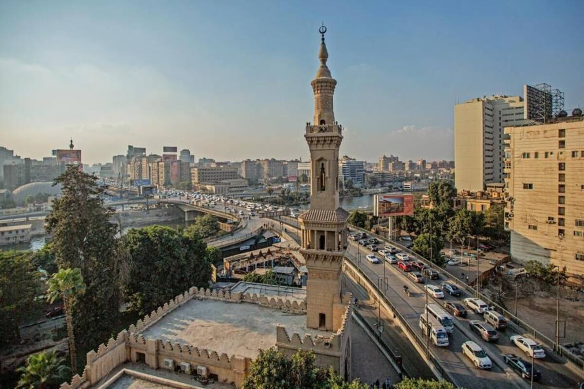 A cityscape with a prominent tower, busy roads, and modern buildings.