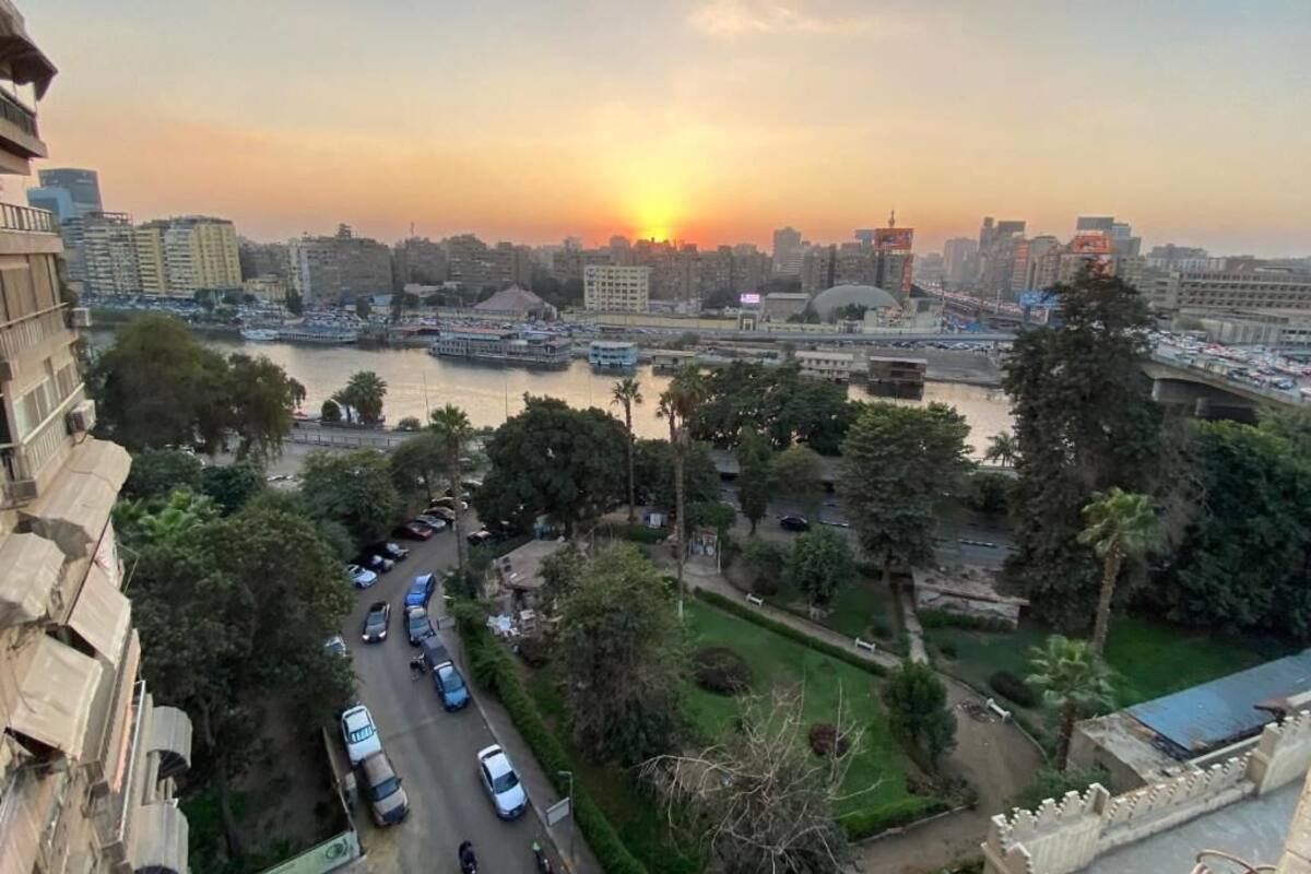 A cityscape with a river, buildings, and a sunset.