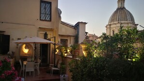 A courtyard with outdoor seating, a fountain, and a building with a dome in the background. - Palais Romain Historique Piazza Navona AU Coeur DE Rome (Rome)