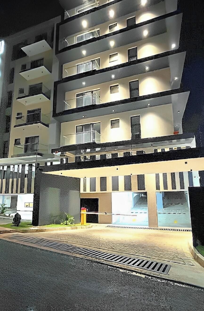 A multi-story hotel with balconies, a covered entrance, and a well-lit facade.