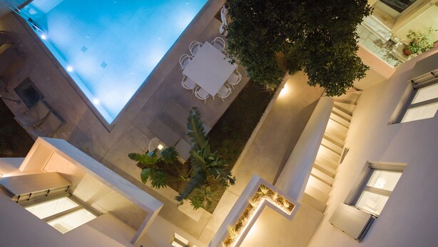 A modern building with a swimming pool, multiple balconies, and a central garden area. - TWO VAULTS, Rethymno old town (Rethymno)