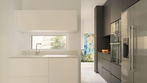A modern kitchen with a window, stainless steel appliances, and a view of a mural. - TWO VAULTS, Rethymno old town (Rethymno)