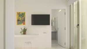 A modern bathroom with a glass shower enclosure, a mounted TV, and a small potted plant. - TWO VAULTS, Rethymno old town (Rethymno)