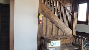 A wooden staircase with a fire extinguisher and a 'WELCOME' sign.