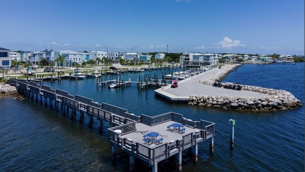 A marina with a dock extending into calm water, surrounded by residential buildings. - New Listing Sea Side Paradise.  Best of Key Largo! (Key Largo)