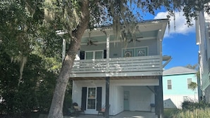 A two-story house with a covered front porch, a garage, and a small front yard. - Refreshing & Peaceful Southern Inlet Beach House! (Murrels Inlet)
