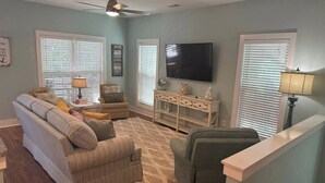 A living room with a sofa, armchairs, a coffee table, a TV, and a sideboard. - Refreshing & Peaceful Southern Inlet Beach House! (Murrels Inlet)