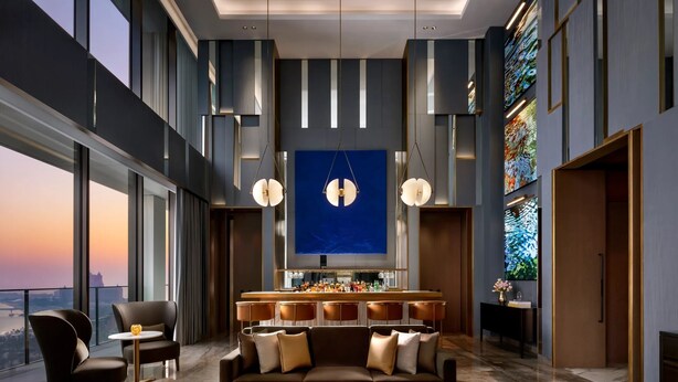 A modern hotel lobby with a bar area, seating, and large windows offering a city view. - Limited Edition (Addis Ababa)