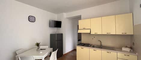 Cafetera o tetera, frigorífico, horno y placa de cocina