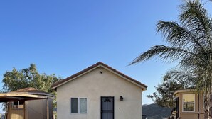 A single-story building with a flat roof and a small porch. - Affordable guest house  (Perris)