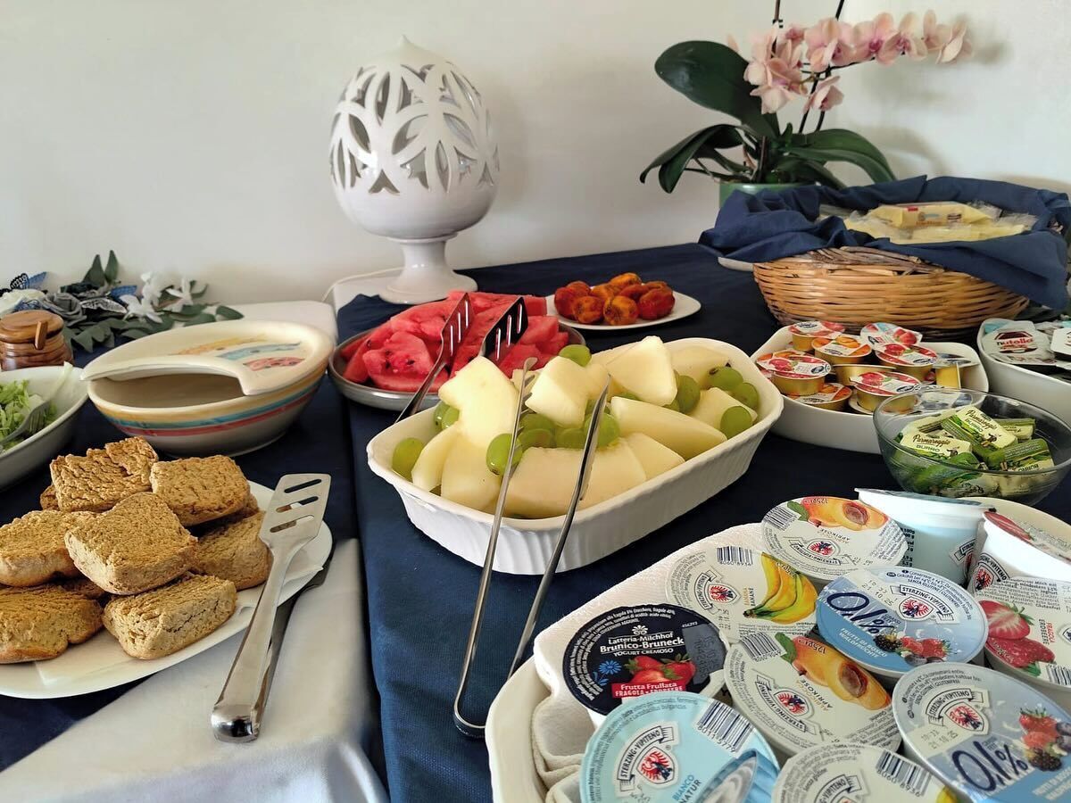 Una mesa con diferentes alimentos, como pan, frutas y yogur.