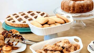 A variety of baked goods including a lattice-topped pie, a bundt cake, and several types of cookies and pastries.