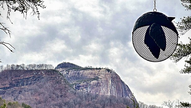 Vista de una montaña con una terraza de madera al frente.