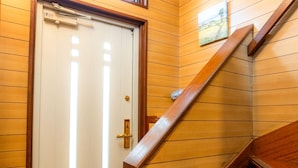 Een houten interieur met een trap, een deur en een klein raam.