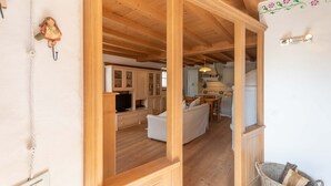 A wooden interior with a dining area, kitchen, and living room. - Casa Roberto (Moena)