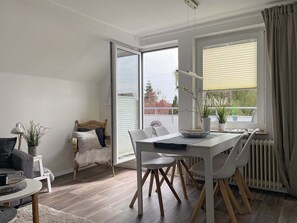Una sala moderna con comedor, un sofá, una silla y una mesa.
