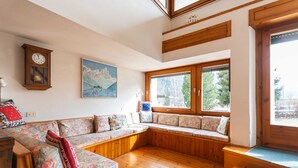 A cozy living room with a wooden bench, a clock, and a painting on the wall.