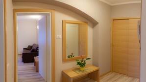 A hallway with a wooden bench, a mirror, and a door. - Regina 4 (Alleghe)