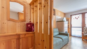 Ein Holzinterieur mit einer Couch, einem Spiegel und einer roten Tasche auf einem Holzschrank.