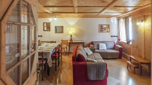 A cozy wooden interior with a dining area, a sofa, and a bench. - Casa Cristina (Campitello di Fassa)