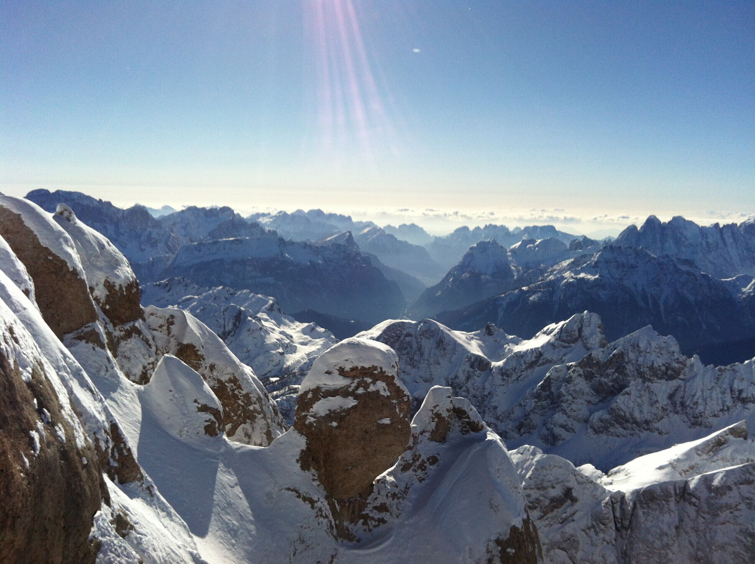 Een panoramisch uitzicht op besneeuwde bergtoppen onder een heldere lucht.