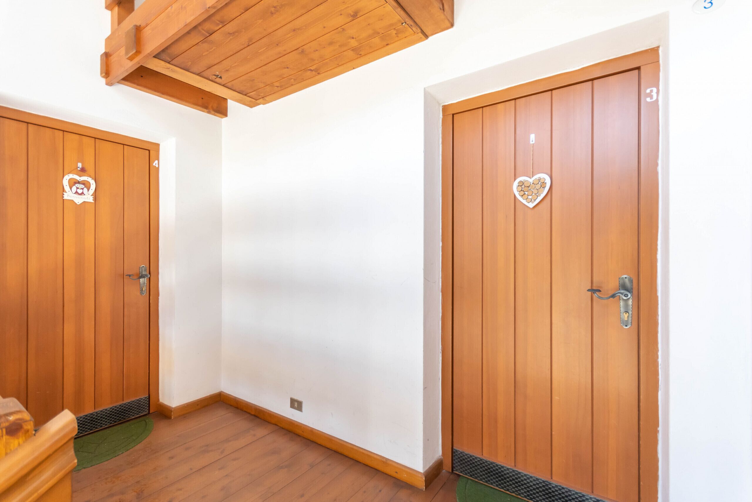 Ein Hotelzimmer mit Holztüren, einer grünen Matte am Eingang und einer Holzkονde.