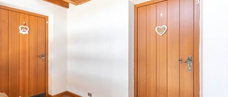 Ein Hotelzimmer mit Holztüren, einer grünen Matte am Eingang und einer Holzkονde.