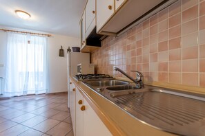 Fridge, microwave, coffee/tea maker, cookware/dishes/utensils