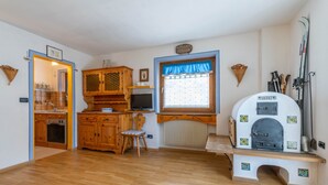 A kitchen with wooden cabinets, a built-in oven, and a window with a blue curtain.