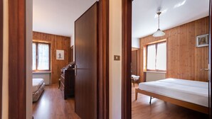Une pièce aux murs en bois, avec un lit, un bureau et une chaise.