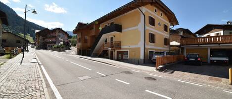 A street with buildings, a clear sky, and a mountain in the background.