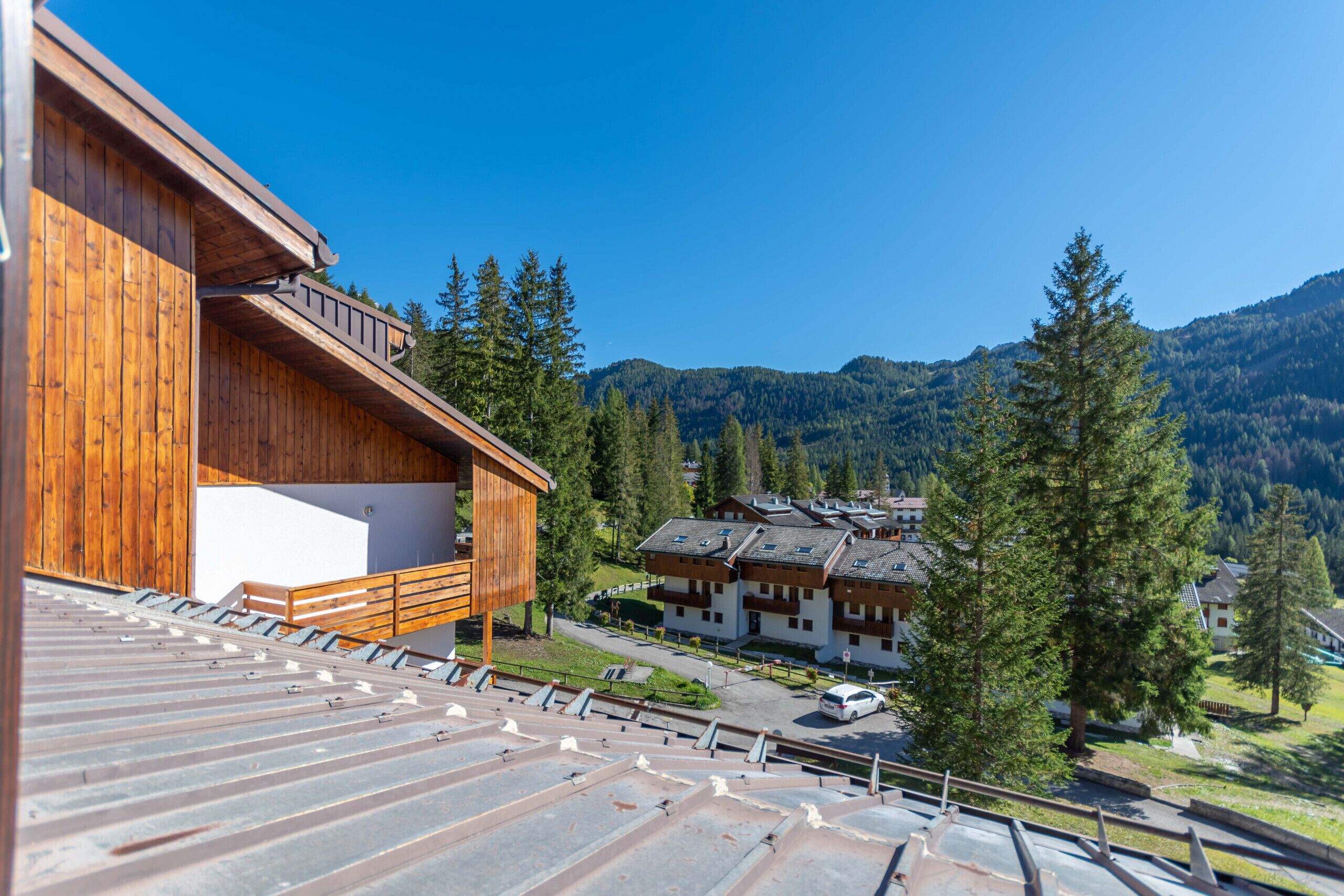 Un bâtiment en bois doté d’un balcon, d’un télésiège et offrant une vue sur la montagne.