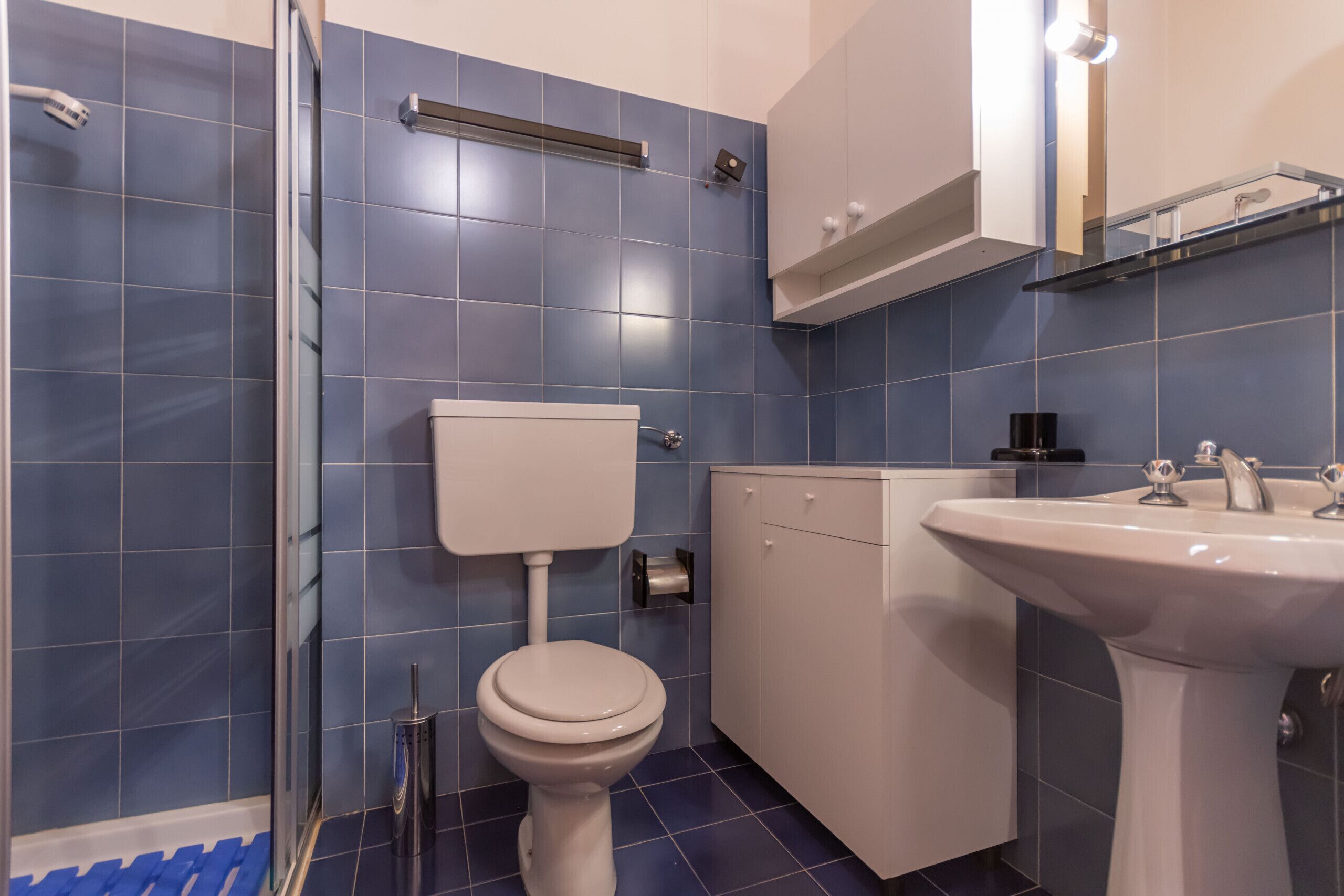 A bathroom with a toilet, sink, and shower.