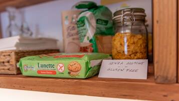 Una estantería con una caja de muffins sin gluten, un tarro de granola y una nota que dice 'Senza Glutine - Gluten Free'.