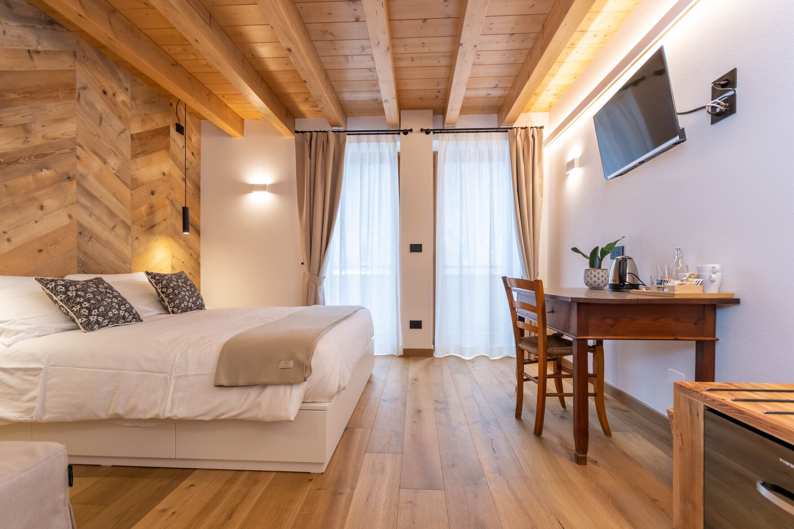 Ein Schlafzimmer mit Bett, Schreibtisch und Fernseher.