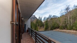 Un balcon avec vue sur une montagne et une forêt.