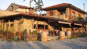 Un edificio rústico con fachada de piedra, vigas de madera y camino de entrada de grava.
