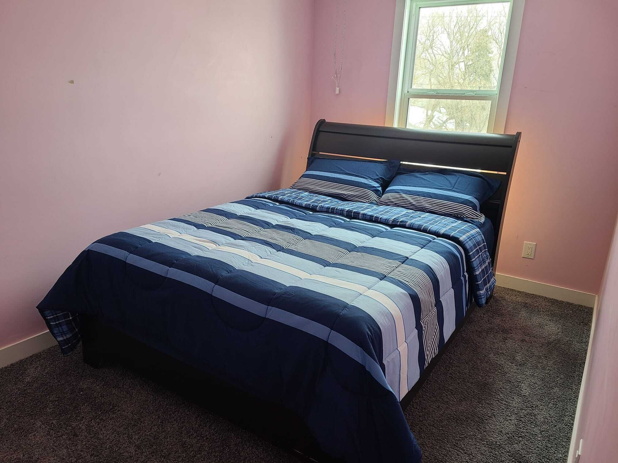 Une chambre à coucher avec un lit, une fenêtre et un sol recouvert de moquette.