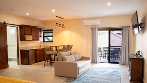 Una cocina moderna con comedor, sofá y televisor.
