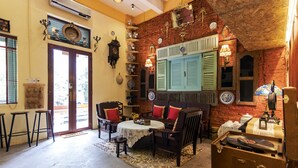 A cozy room with a rustic brick wall, a wooden table with chairs, and a vintage sewing machine.