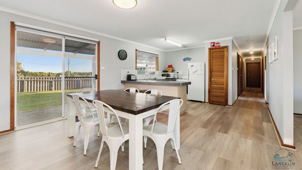 A modern kitchen with a dining area, large windows, and a view of the outdoors. - Sea Breeze A cosy 4/1 holiday home, just 300m from Lancelin Back Beach (Lancelin)
