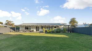 A residential house with a covered patio, a fenced backyard, and a well-maintained lawn. - Sea Breeze A cosy 4/1 holiday home, just 300m from Lancelin Back Beach (Lancelin)