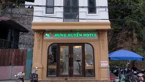 Un bâtiment sur lequel on peut lire l’inscription « Hung Huyen Hotel » et, au-dessus de l’entrée, « Charming Hill Hotel ».
